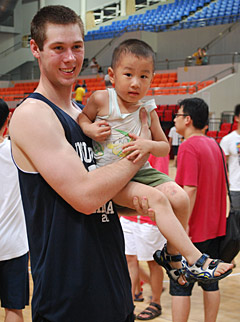Augustana's Kyle Nelson holds a young boy after the game
